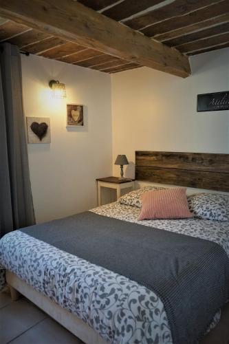 une chambre avec un grand lit dans une pièce dans l'établissement Les figues et les cigales, à Hyères