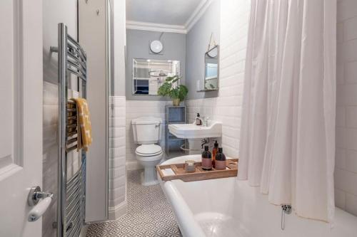 a bathroom with a tub and a toilet and a sink at Beautiful apartment in Bath in Bath