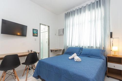 1 Schlafzimmer mit einem blauen Bett und 2 Stühlen in der Unterkunft Novo e Confortável Studio no RJ/Lapa Circo Voador in Rio de Janeiro