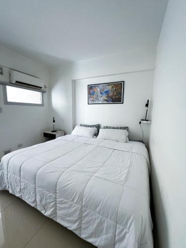 1 dormitorio blanco con 1 cama blanca grande en Departamento en Villa Crespo en Buenos Aires