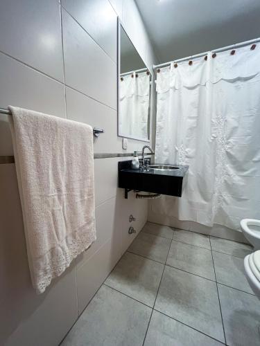 uma casa de banho com lavatório, espelho e toalhas em Luminoso departamento en Villa Crespo em Buenos Aires