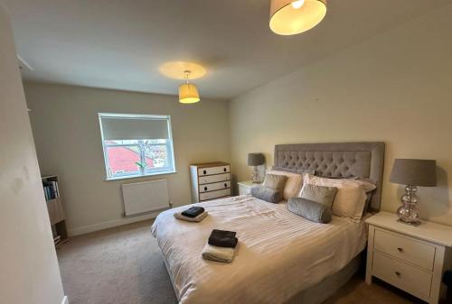 a bedroom with a large bed and a window at 4BR Cheshire East/Townhouse/Central - Close to Bentley in Crewe