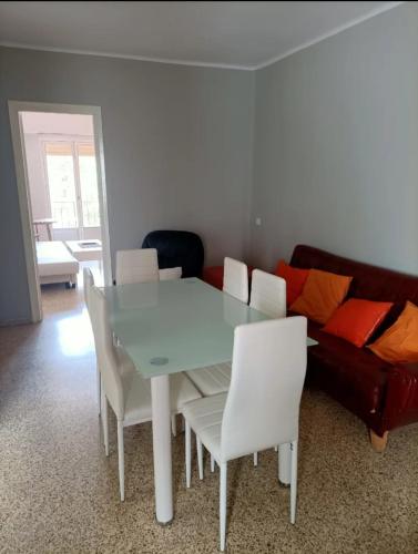 a table and chairs in a living room with a couch at El Molino Buñol Apartamento in Buñol