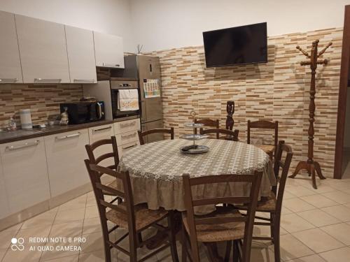 une cuisine avec une table et des chaises ainsi qu'une télévision dans l'établissement Martino10, à Carloforte