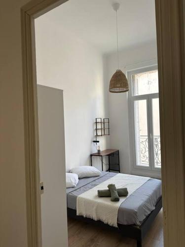une chambre avec un lit et une fenêtre dans l'établissement Superbe Appartement - 3 chambres (5 min Vieux Port - Rue Paradis), à Marseille