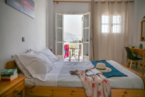 a bedroom with a bed and a table and a window at Pension St.George Rooms & Studios in Perivolos