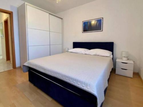 a bedroom with a large bed with a blue headboard at Nice apartment -with new private pool in Stari Grad