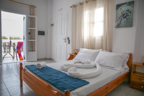 1 dormitorio con 1 cama con toallas en Pension St.George Rooms & Studios, en Perivolos