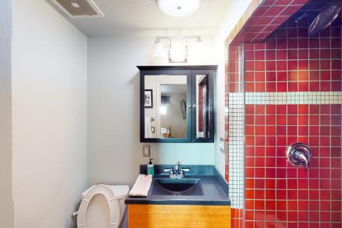 y baño con lavabo, aseo y espejo. en Red Rocks Retreat en Englewood