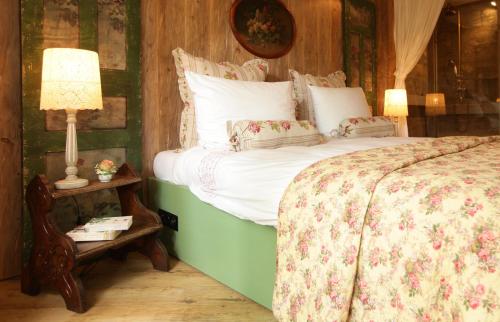 a bedroom with a bed and a table with a lamp at Weißt Du noch - Gästehäuser & Suiten in Kühlungsborn