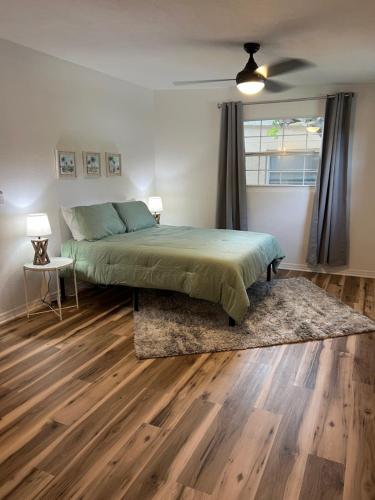 um quarto com uma cama, pisos em madeira e uma janela em Clearwater Creek Home in Superb Location em Clearwater