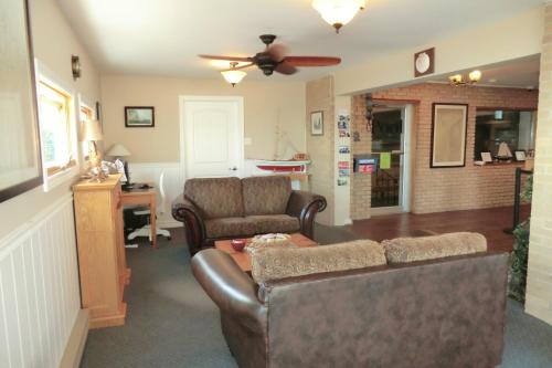a living room with a couch and a ceiling fan at Admiral Digby Inn Restaurant and Cottages in Digby