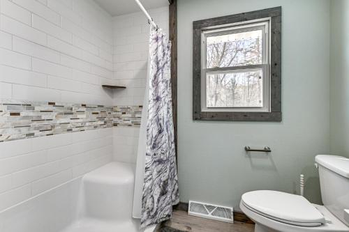 La salle de bains est pourvue d'une baignoire, de toilettes et d'une fenêtre. dans l'établissement Wausau Home with Yard 1 Mi to Granite Peak Ski Area, à Wausau