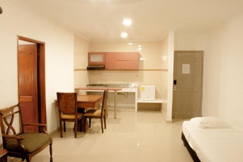 a small room with a kitchen and a table and chairs at Hotel Yivinaca in Barranquilla