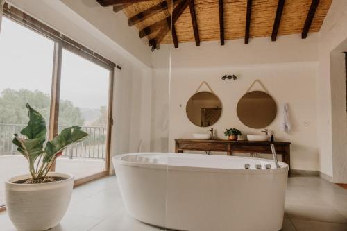 a bathroom with a large tub and a plant at Pietra Hotel in Sáchica