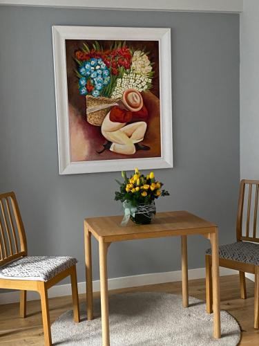 a painting of a woman with flowers on a table at preciosa casa,garage wifi 4 personas in Vigo