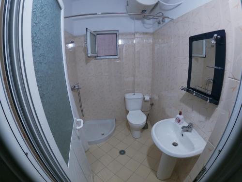 a bathroom with a toilet and a sink at Tulipani Apartments near port in Sarandë