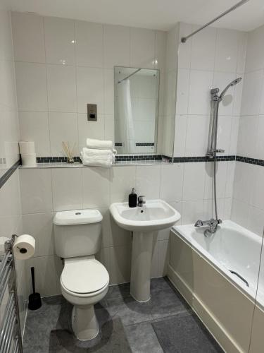 a bathroom with a toilet and a sink and a tub at Spacious 2 Bedrooms Apartment In Stratford in London