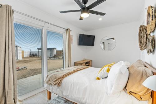 - une chambre avec un lit et une grande fenêtre dans l'établissement Private Joshua Tree Cabin w/ Hammocks & Campfire, à Yucca Valley