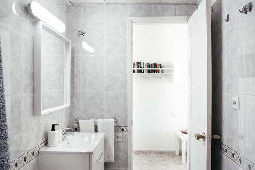 uma casa de banho branca com um lavatório e um espelho em Apartamento Sol y Mar em San Bartolomé