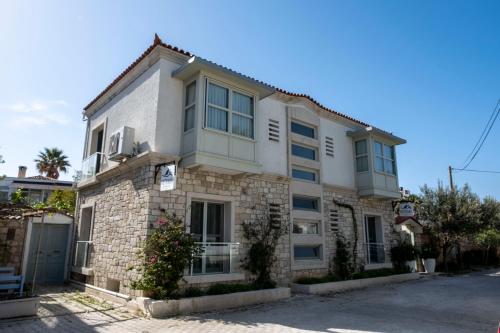 a large white building on a street at Kotraba Alacati Hotel in Alacati