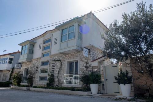 a large building with trees in front of it at Kotraba Alacati Hotel in Alacati