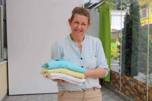 a woman is holding a pile of towels at Hotel Casa botero 106 in Bogotá