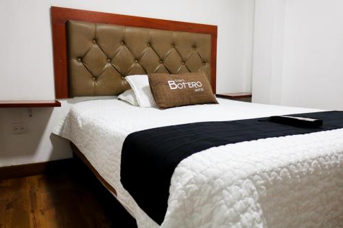 uma cama com um edredão preto e branco e uma almofada em Hotel Casa botero 106 em Bogotá