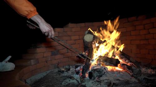 a person holding a stick over a fire at MEYAHUALLI GLAMPING in Huasca de Ocampo