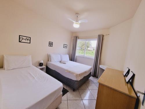 a hotel room with two beds and a window at Residencial Cristina's-Apartamentos de 2-3 Quartos equipados com WiFi Garagem-Excelente Localização in Lages