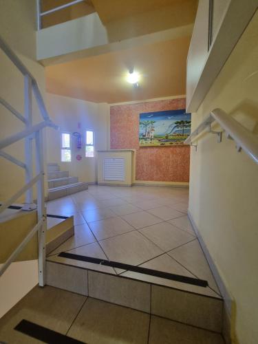 una habitación vacía con escaleras y una pintura en la pared en Residencial Cristina's-Apartamentos de 2-3 Quartos equipados com WiFi Garagem-Excelente Localização, en Lages