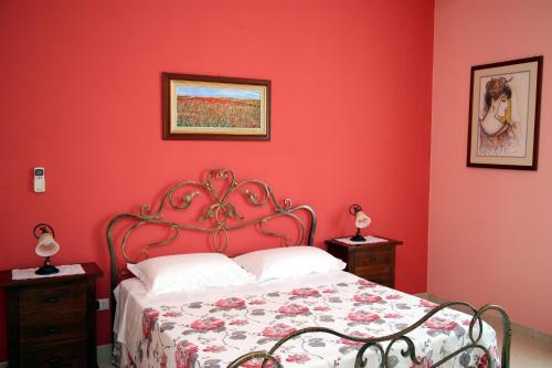 a red bedroom with a bed with a red wall at B&B Borgosolare in Specchia