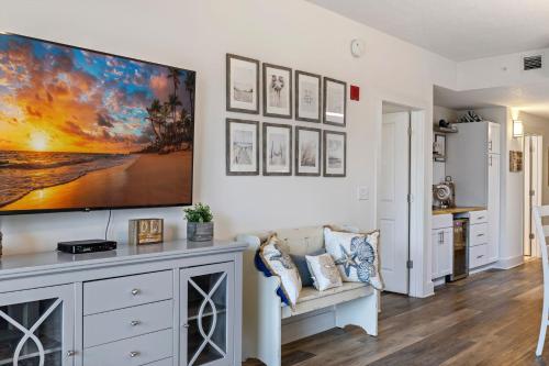a living room with a large tv on a wall at Calypso 3 New Relax Unwind Luxury PCB next to Pier Park 3 Bed 2 Bath Pool Hot Tub Tikki bar in Panama City Beach