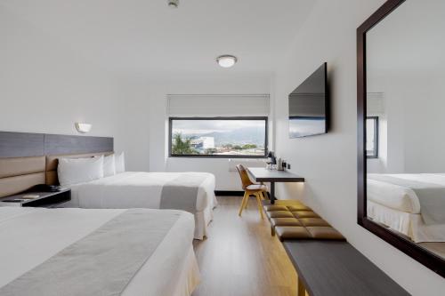 a hotel room with two beds and a window at Parque del Lago Boutique Hotel in San José