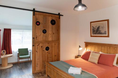 1 dormitorio con 1 cama y puerta de madera en Devon Eleven en Rotorua