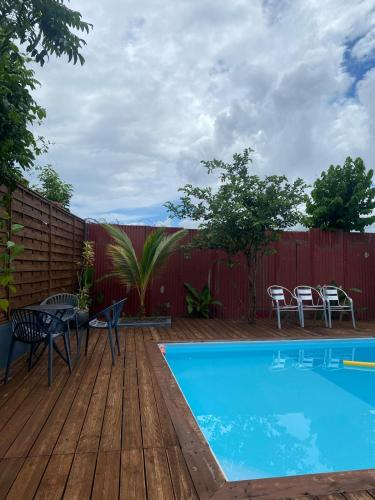 a backyard with a swimming pool and a wooden deck at T3 VILLA DAGONI LOGONI in Koungou