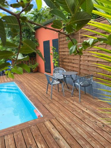a deck with a table and chairs next to a pool at T3 VILLA DAGONI LOGONI in Koungou