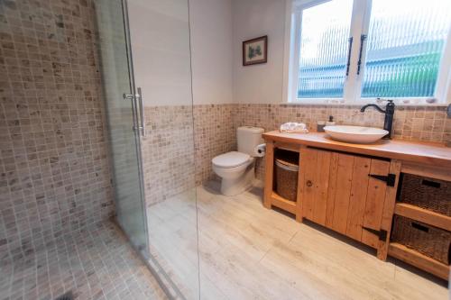 La salle de bains est pourvue de toilettes, d'un lavabo et d'une douche. dans l'établissement Devon Eleven, à Rotorua