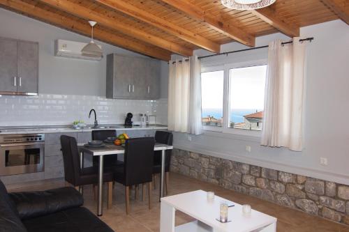 a kitchen and living room with a table and a counter at Emilia's Guest House Upper Floor in Stoupa
