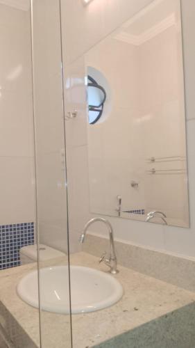 a bathroom with a sink and a glass shower at Hotel Lagoinha in Ubatuba