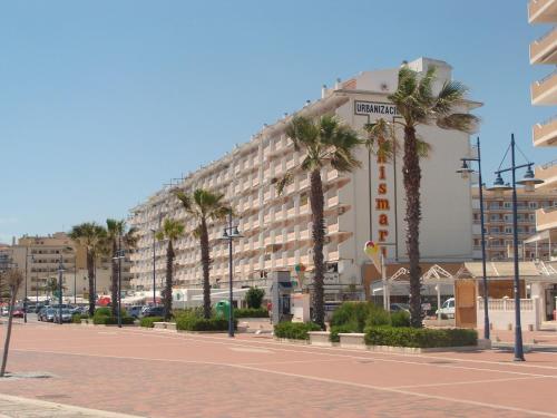 un gran edificio con palmeras delante en Alpen1 Peñismar I, en Peñíscola