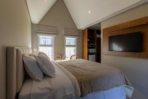 1 dormitorio con 1 cama y TV de pantalla plana en Onze Tuin vilinha típica en Holambra