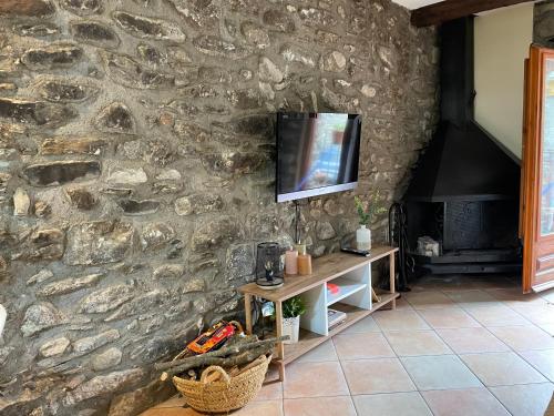 una pared de piedra con un televisor encima. en Apartament Cal Barracaire, en Vilallonga de Ter