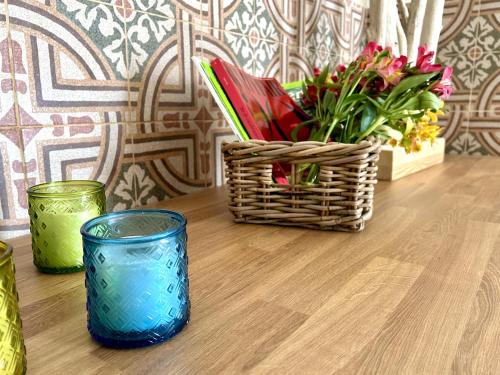 un tavolo con un cesto di fiori e un bicchiere di La Vetrana Rooms ad Avetrana