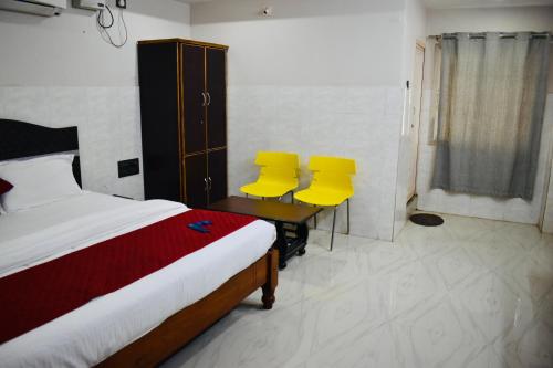 a bedroom with two yellow chairs and a bed at Hotel Unique Stays in Rājampet