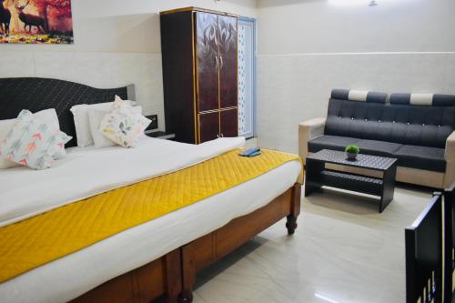 a bedroom with a large bed and a couch at Hotel Unique Stays in Rājampet