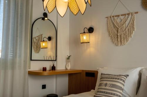 a bedroom with a bed with a mirror and lights at Kotraba Alacati Hotel in Alacati