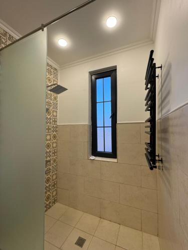 a shower with a glass door and a window at Edits Home in Dsegh