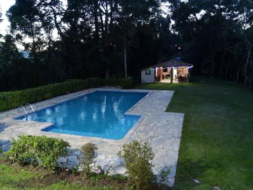 a swimming pool in the middle of a yard at Sitio CANTOS DA FLORESTA in Mairinque