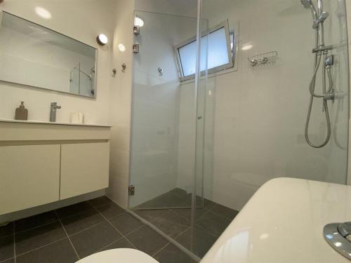 a bathroom with a glass shower and a sink at סויטות הר וים in Neve Zohar